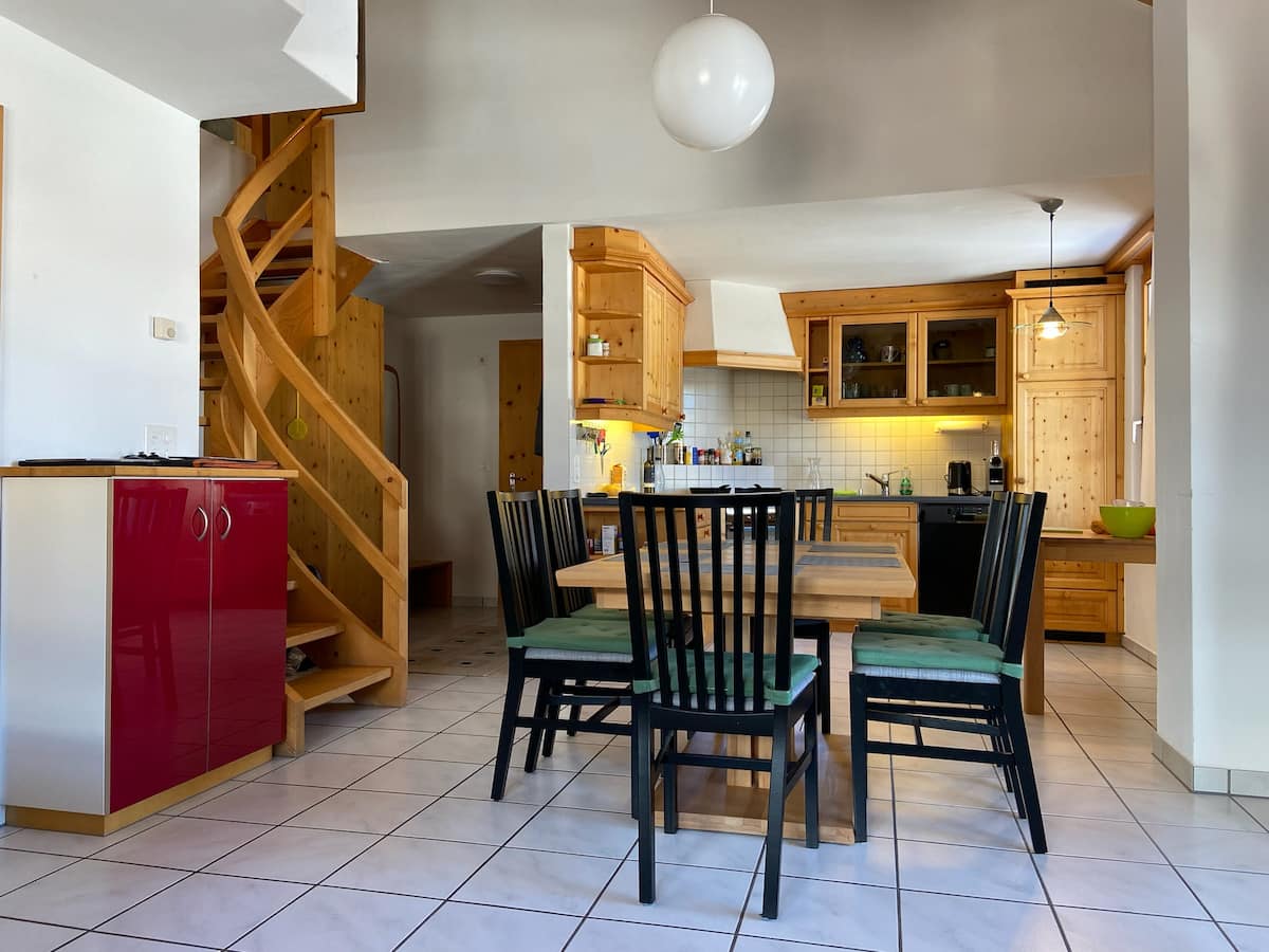 Offene Wohnküche mit Essbereich und Wendeltreppe